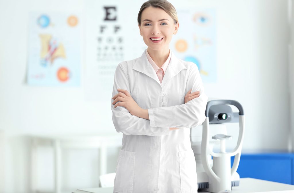 A female optometrist smiling while standing with her arms folded