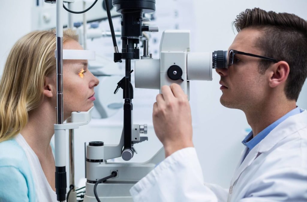 An optometrist performing a slit-lamp exam to detect eye problems.