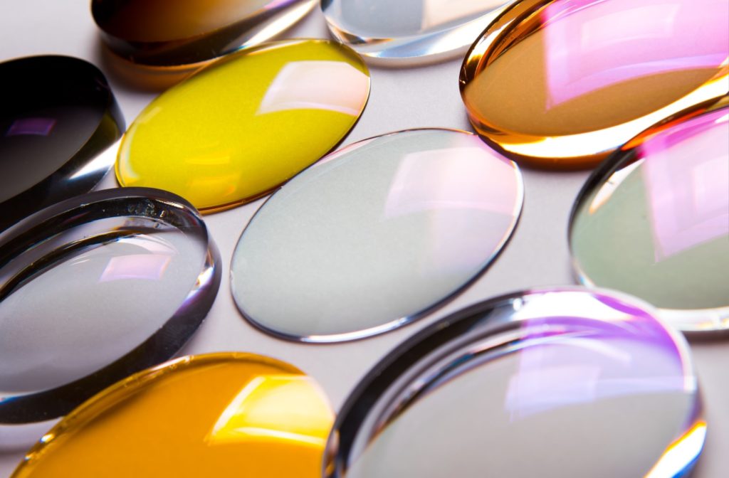 A selection of clear and tinted eyeglass lenses with different types of coatings.