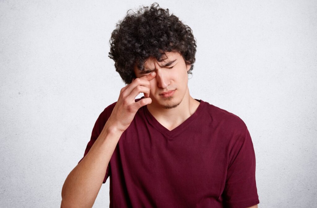 A person rubs their eye to temporarily ease irritation.