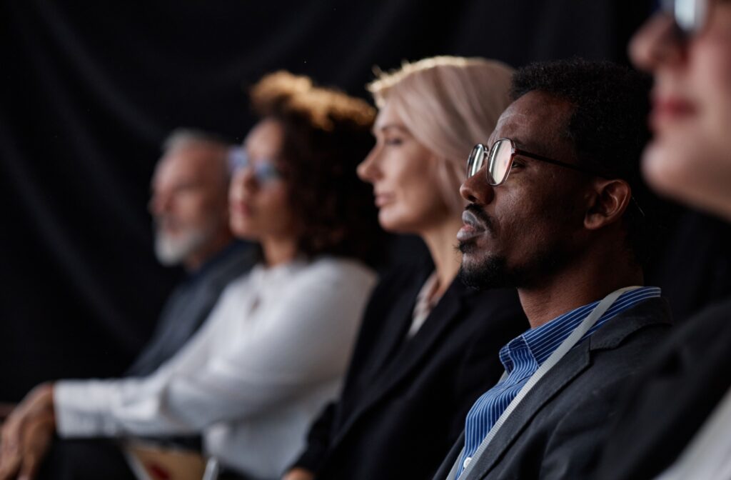 A person wearing hearing enhancing eyeglasses while listening to someone talk to better experience the sound in their environment.