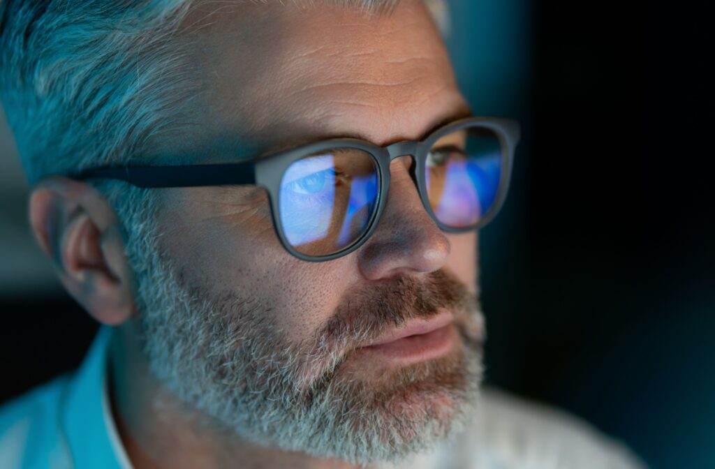 A close up of a person wearing blue light glasses.